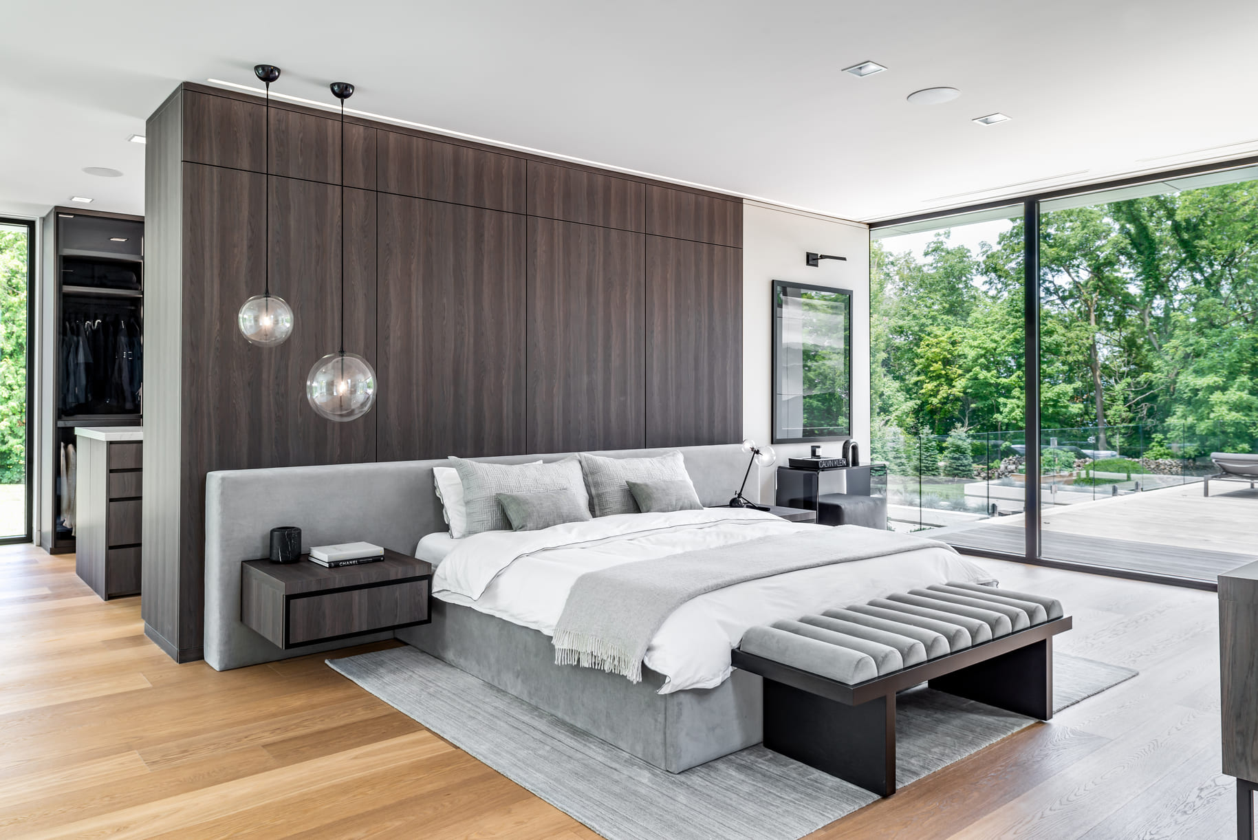 Large master bedroom with a feature wall and floor to ceiling glass windows.